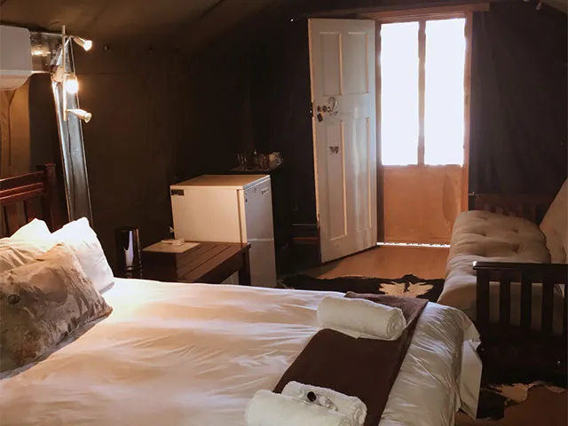 Cozy bedroom with a bed sofa and open door to sunlight
