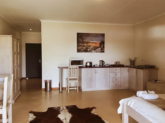 Cozy bedroom with kitchenette bed and cowhide rug on the floor