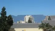 Suburban rooftops with a tall building and mountains in the background