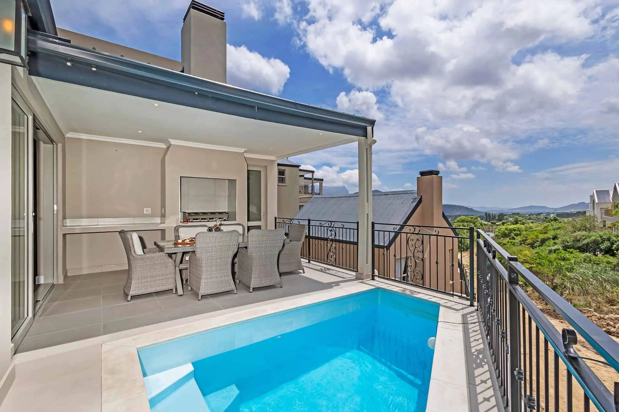 Modern patio with small pool outdoor dining area and scenic view