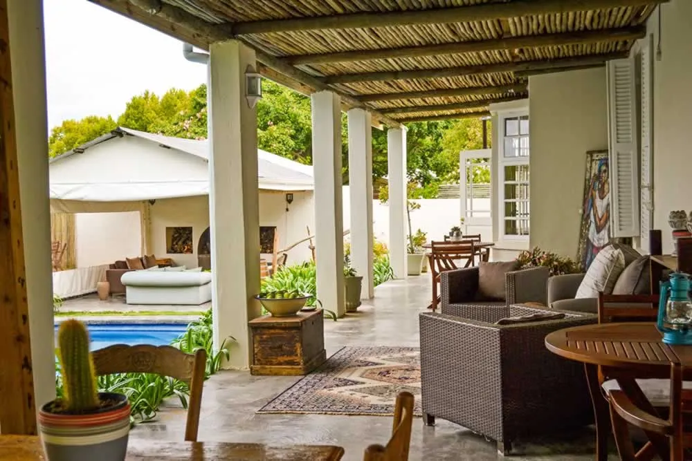 Covered patio with seating area pool and garden view