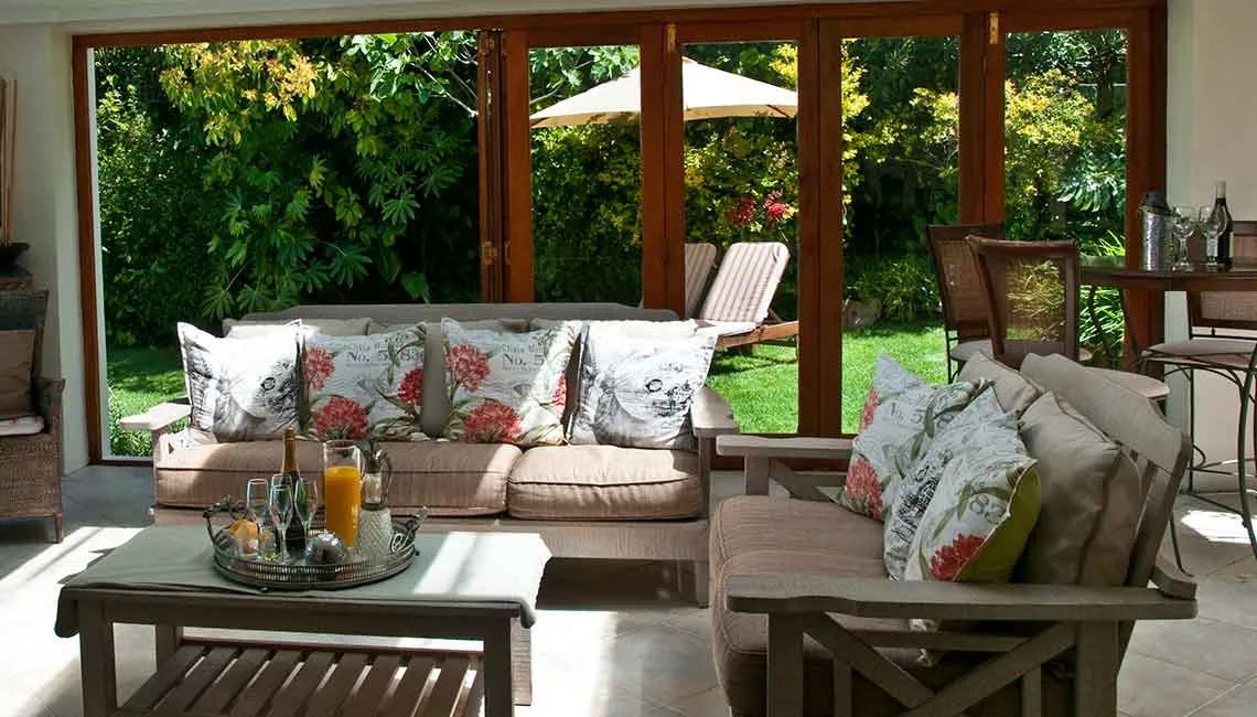 Living room with sofas coffee table and large open doors to garden