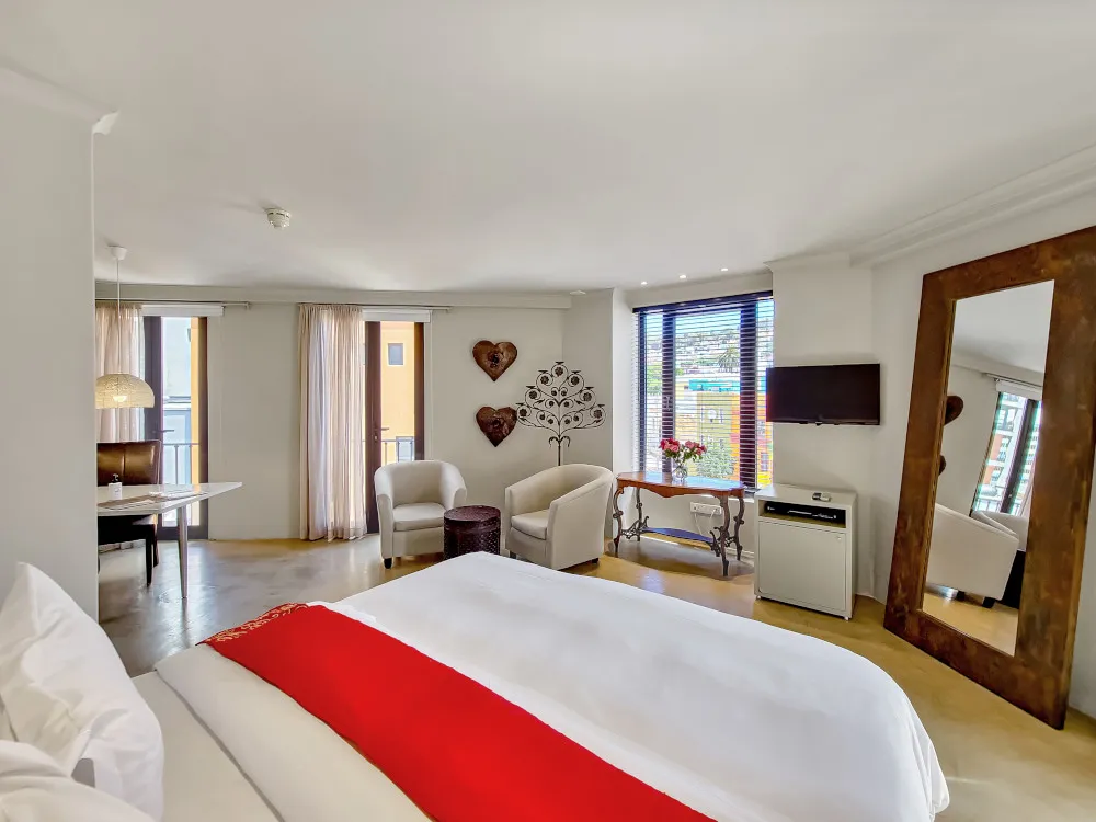 Modern hotel room with large bed seating area and large mirror