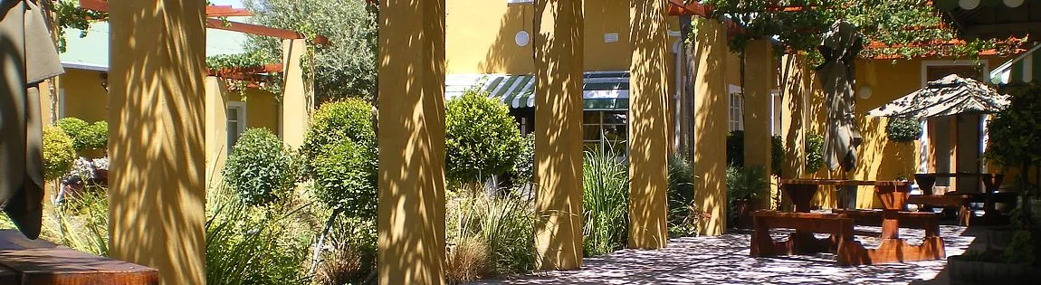 Yellow columns in a garden with wooden benches and greenery