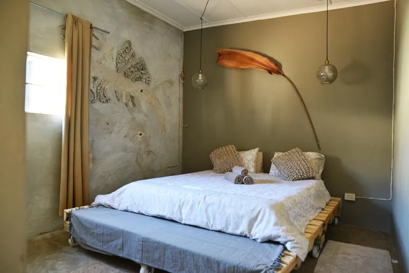 Cozy bedroom with a large bed artistic wall and hanging light fixtures