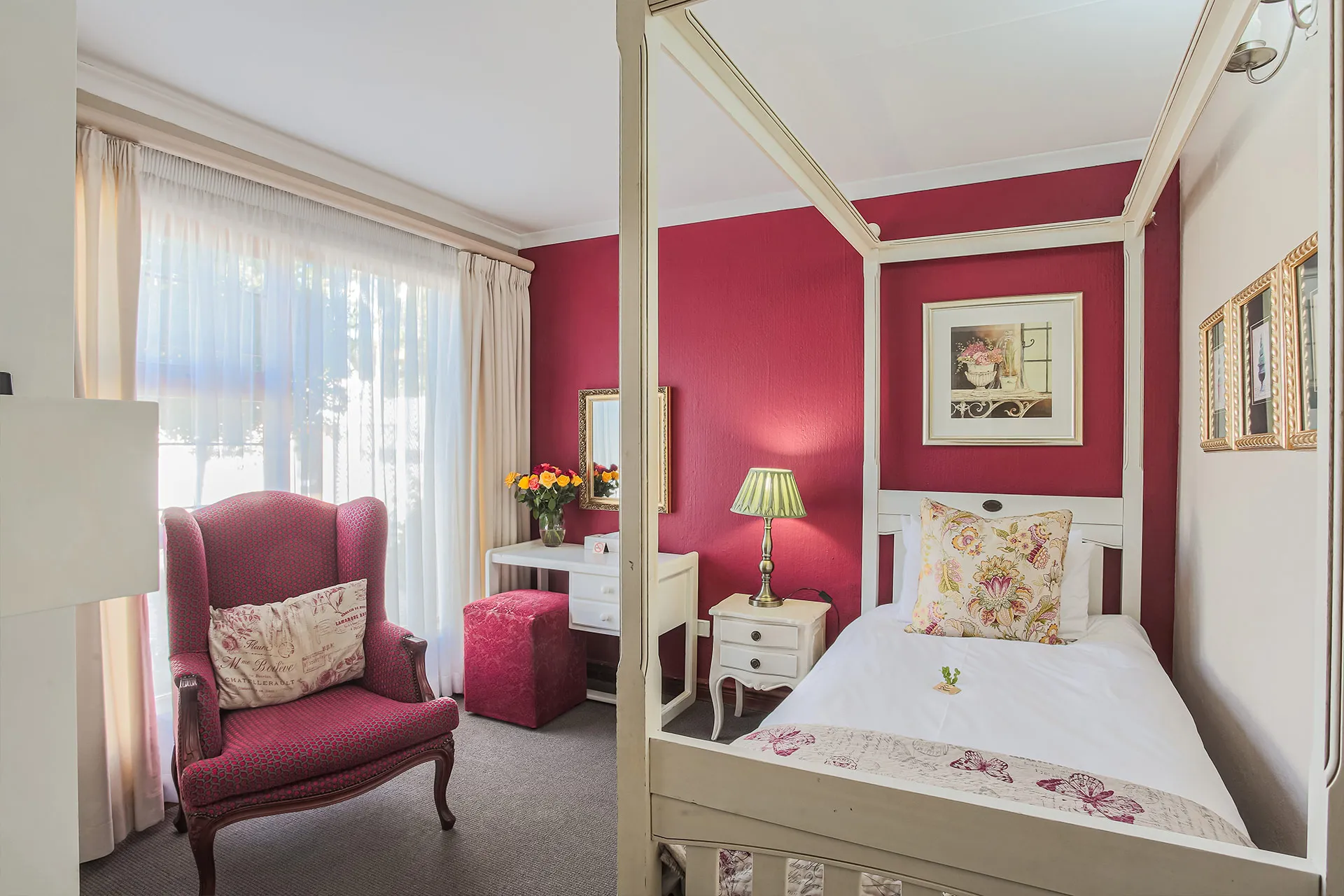 Cozy bedroom with a single bed armchair and floral decor on red walls