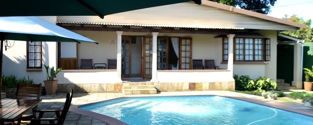 House with a patio and pool outdoor seating area with umbrellas