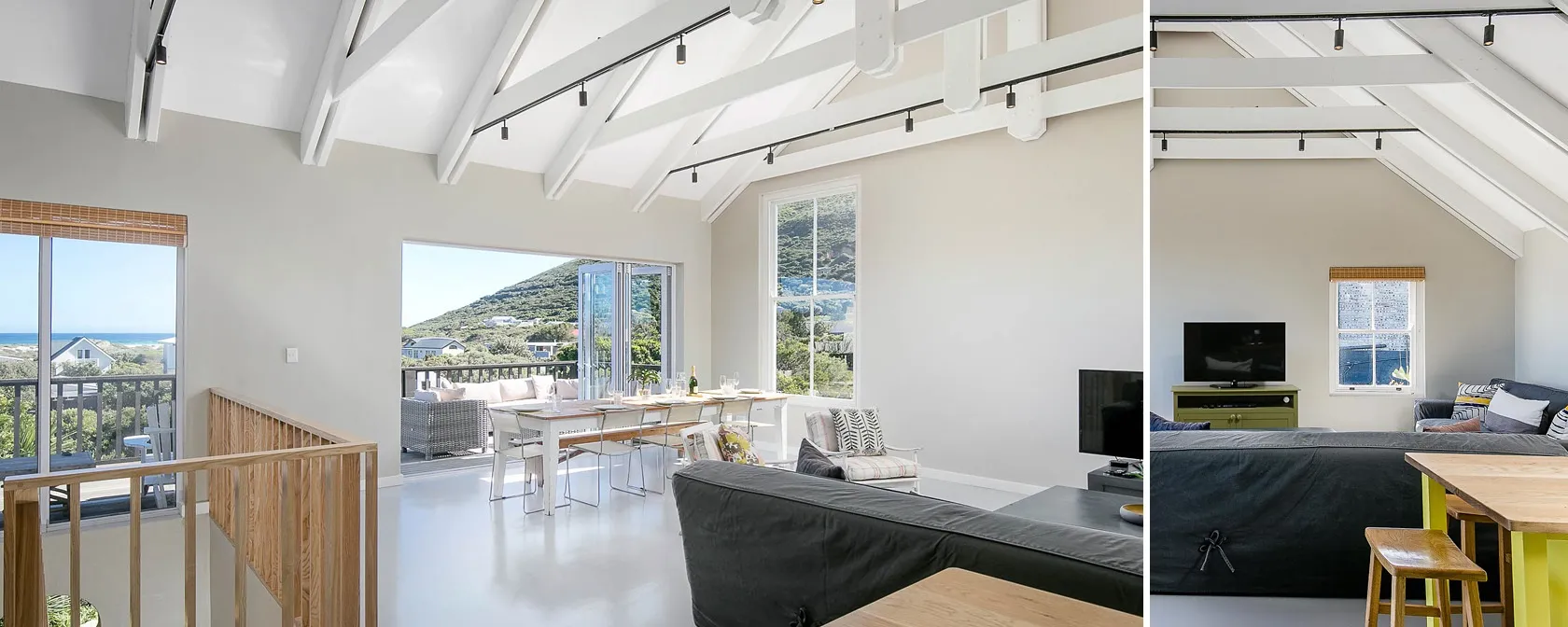 Open living area with high ceilings large windows and ocean view