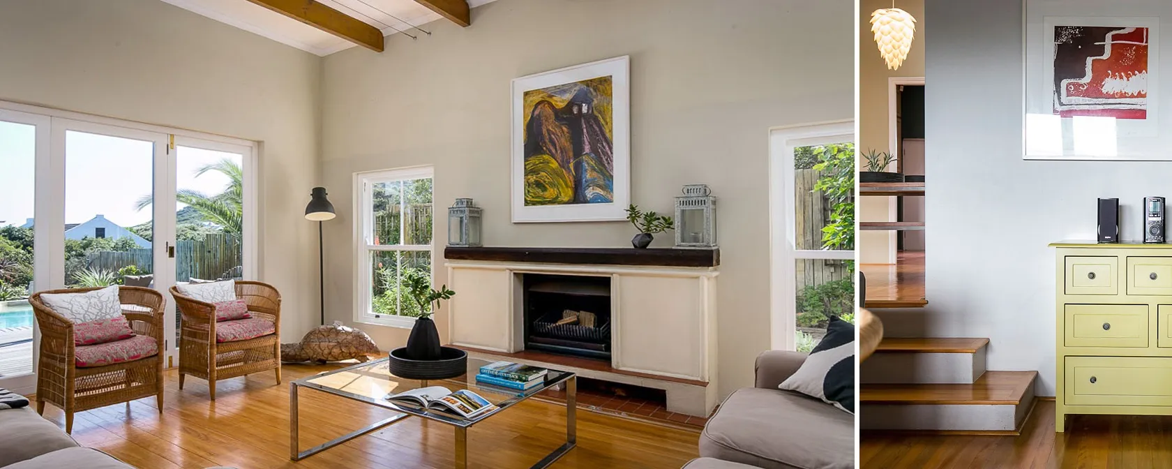 Living room with fireplace wicker chairs and large windows showing a garden view