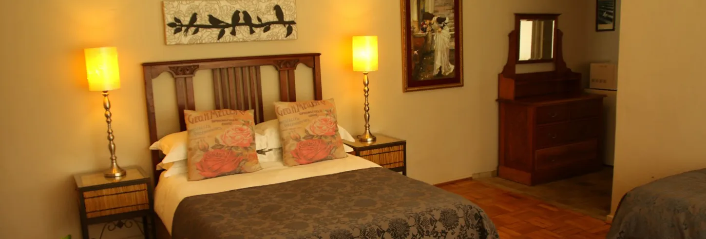 Cozy bedroom with a double bed nightstands lamps and a wooden dresser