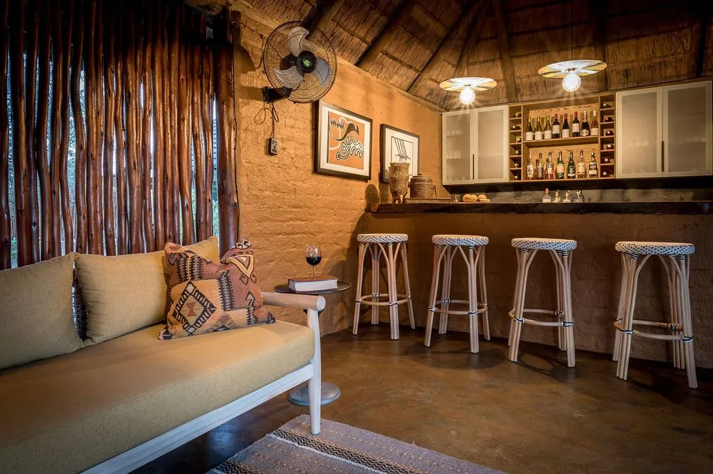 Cozy lounge with sofa bar stools and a wellstocked bar in a rustic setting