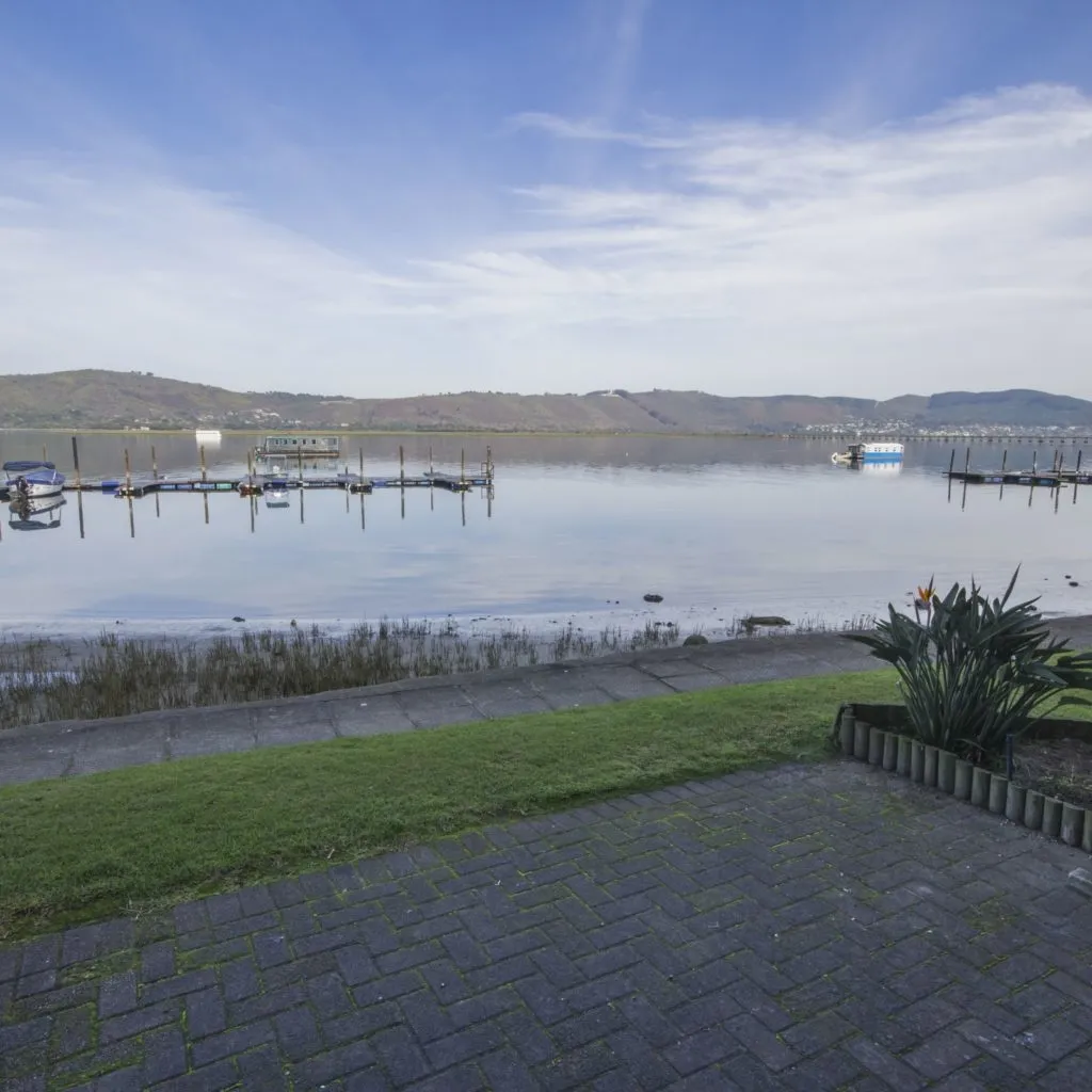 Lake view with boats grassy area and paved walkway