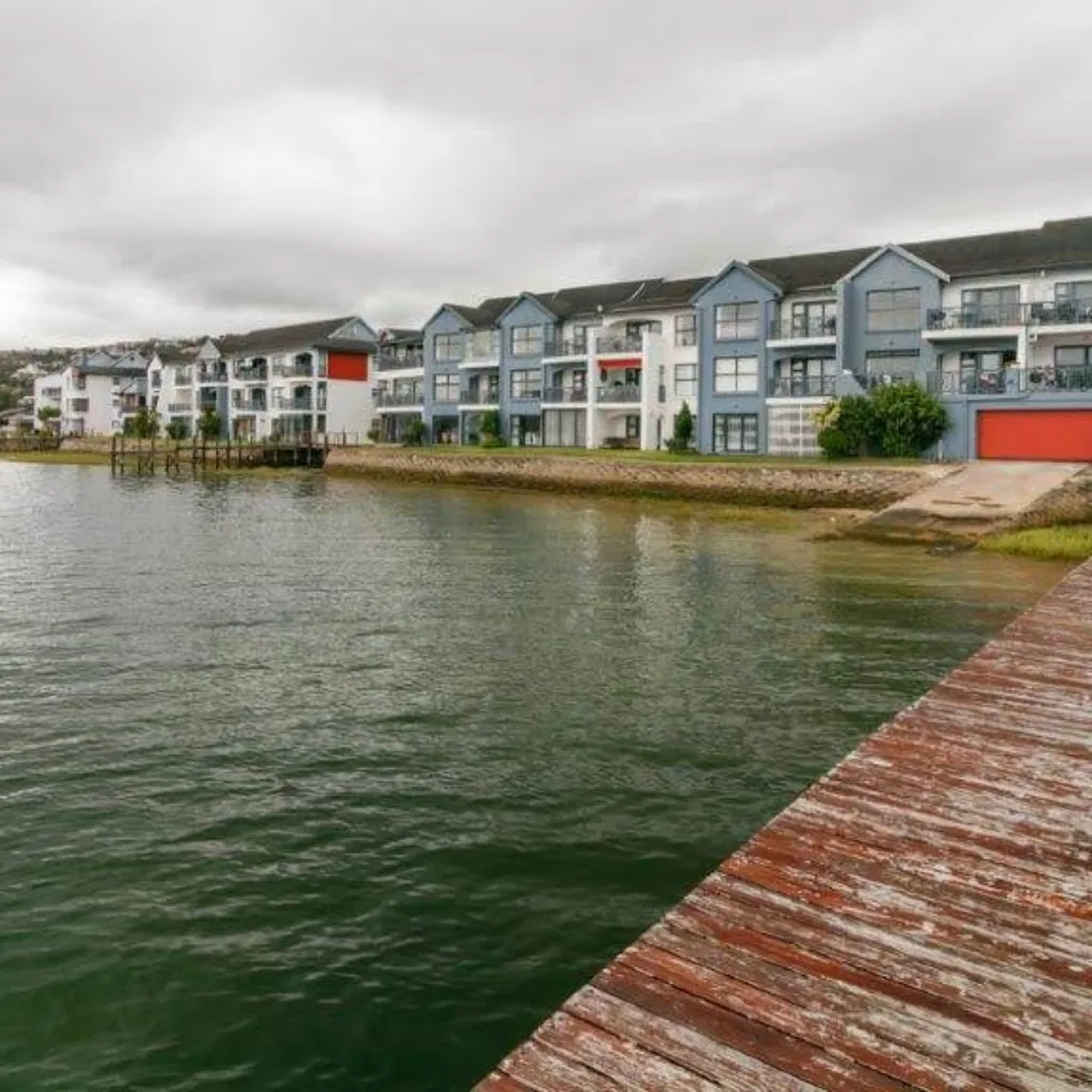 Row of modern waterfront apartments with a wooden dock in the foreground